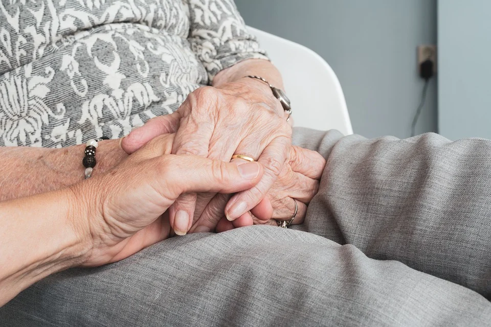 Zwei Senioren halten gegenseitig ihre Hände