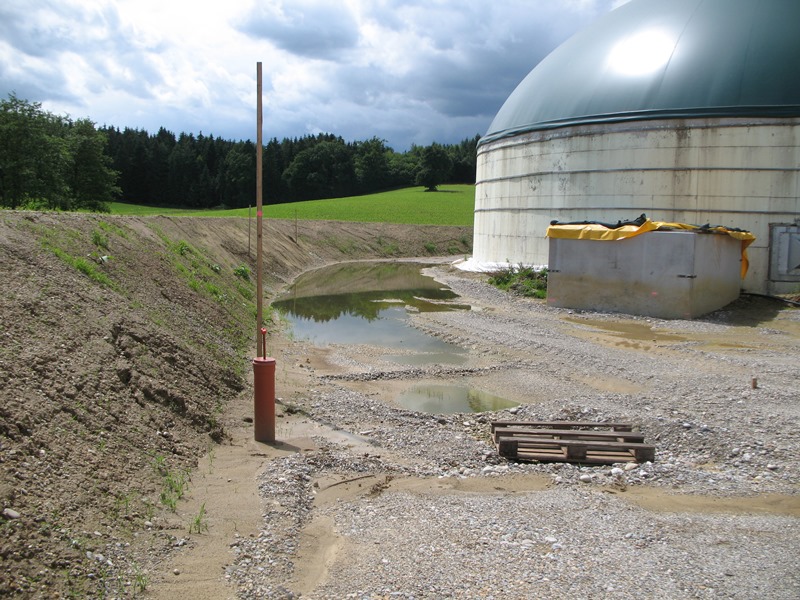 Teile der Biogasanlage Bauer in Almering im Vordergrund eines Waldes