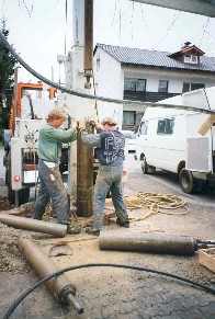 drei Bauarbeiter arbeiten bei einer Brunnenneubohrung