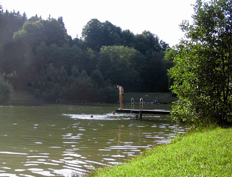 Menschen baden am Badesee Hochmühl neben einem Steg