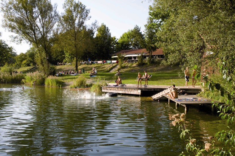 Ufer des Badesees Perach mit Liegewiesen, Stegen und Schilfbewuchs