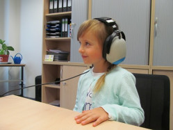 Schulärztliche Untersuchung Hörtest für ein Mädchen während der schulärztlichen Untersuchung