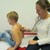 Ärztin hört Jungen bei schulärztlicher Untersuchung mit Stethoskop ab