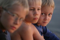 Kinder Drei junge Kinder sitzen nebeneinander