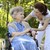 Junge Frau hilft einer Seniorin im Rollstuhl