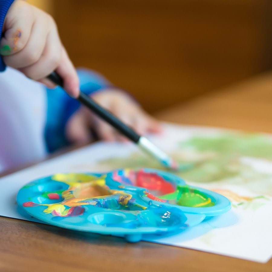 Ein Kind malt mit Wasserfarben