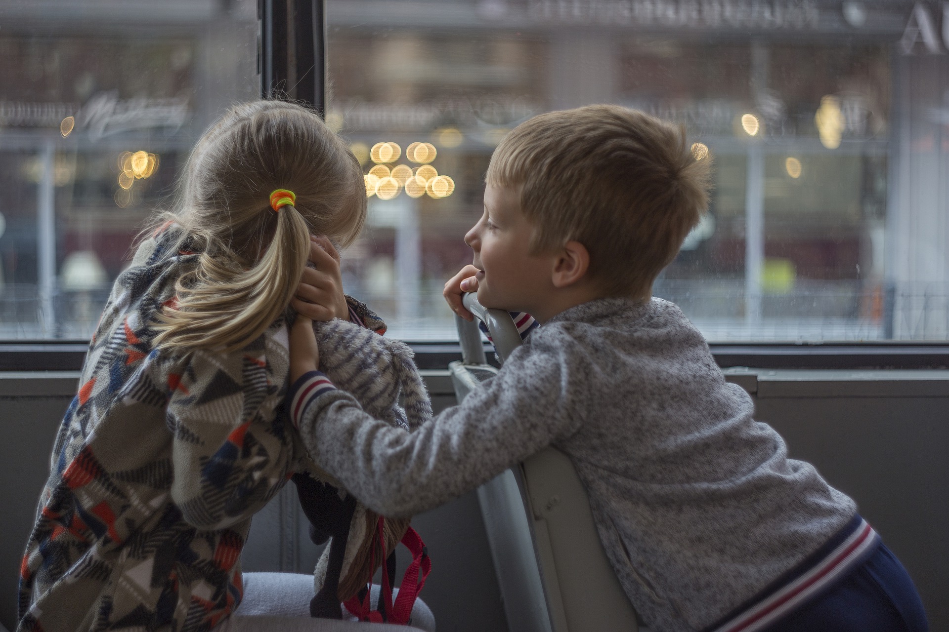 2 Kindern, die im Bus miteinander reden