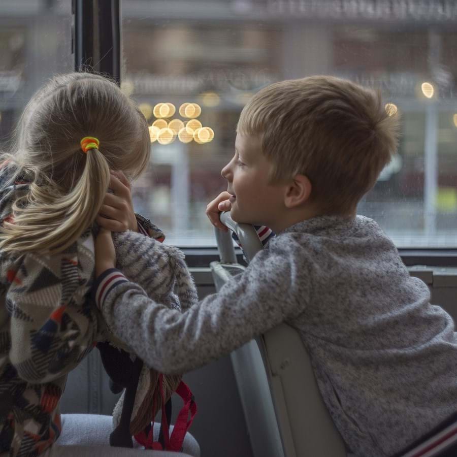 2 Kindern, die im Bus miteinander reden