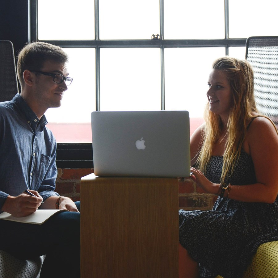 ein Mann und eine Frau führen ein Gespräch an einem Laptop