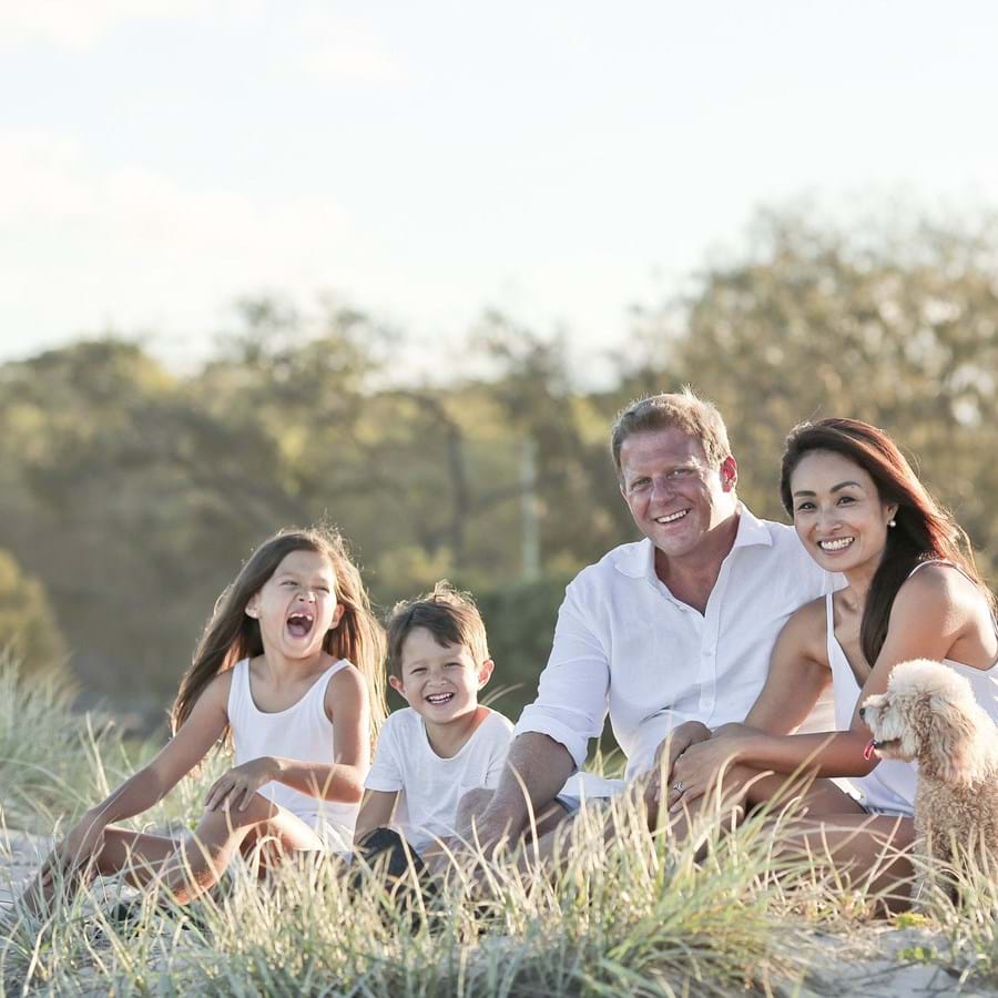 glückliche Familie aus vier Personen sitzt in der Natur