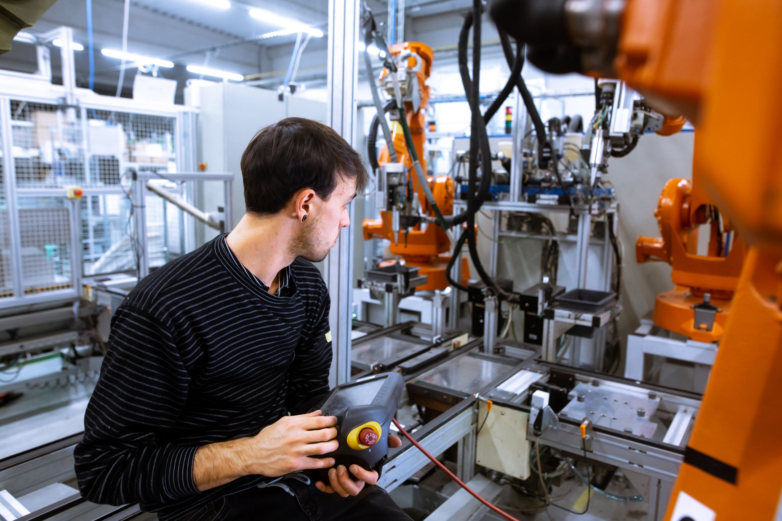 Mann bedient viele Roboter
